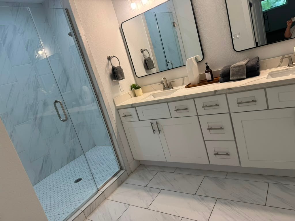 Spotless bathroom with glass shower and double vanity cleaned by Zulma Cleaning Services